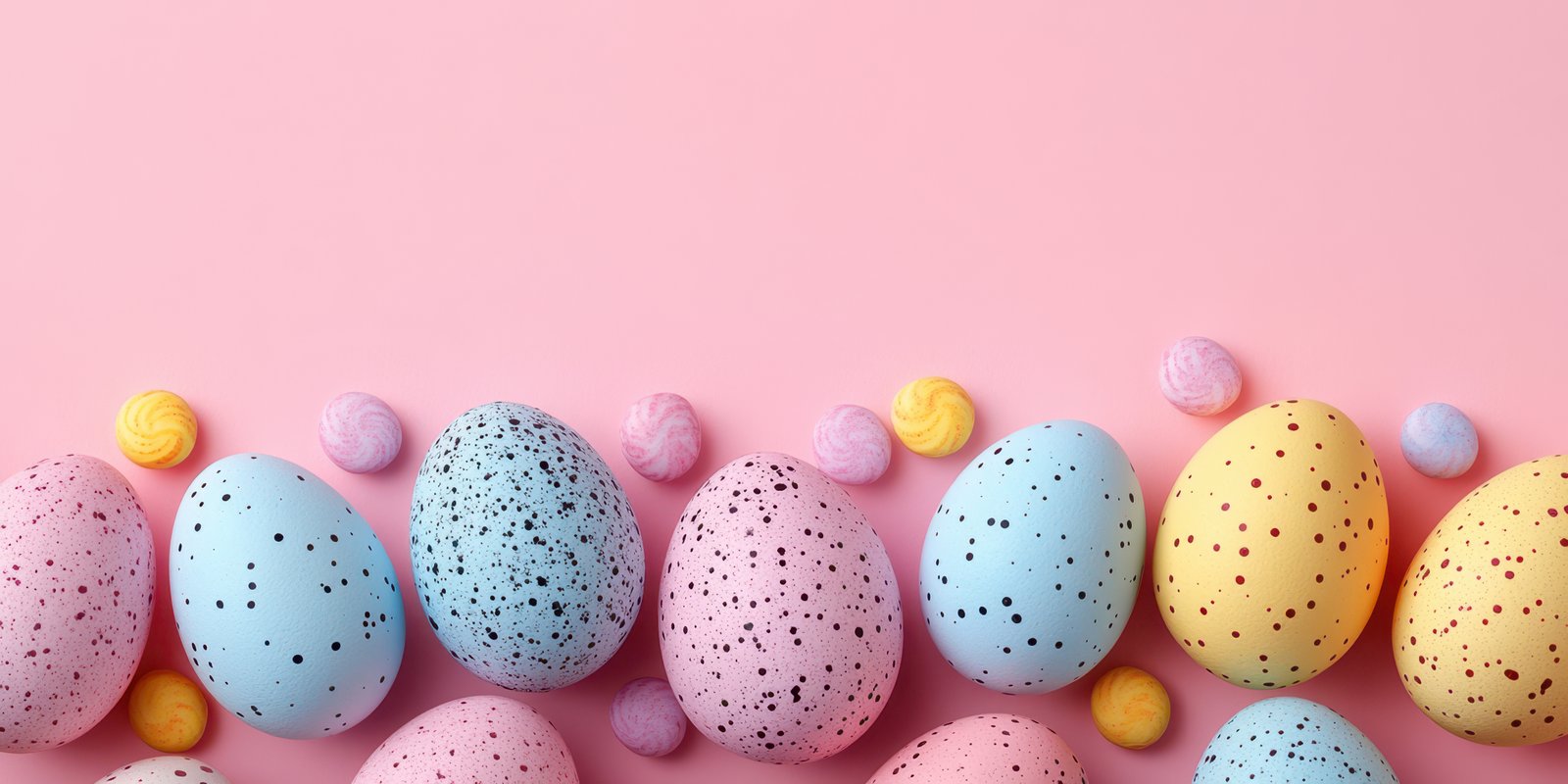 Colorful decorated Easter eggs arranged on a pastel pink background with candy treats for a festive celebration